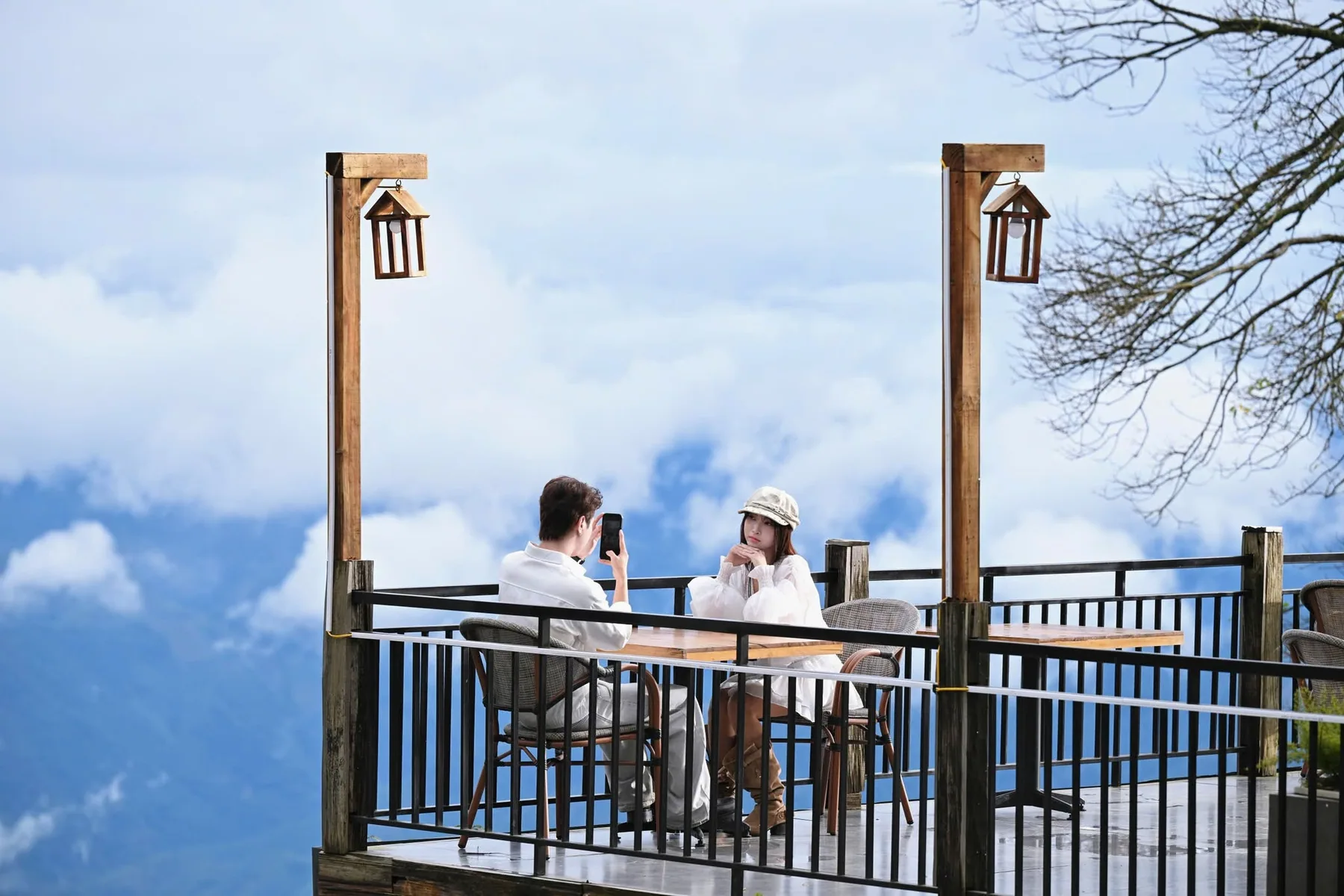 Hai khách ngồi bàn café trên sân hiên giữa biển mây